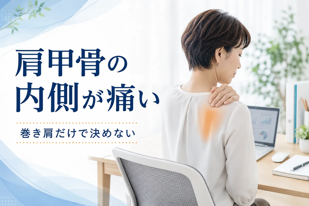 肩甲骨の内側から背骨との間に痛みを感じるデスクワーク中の女性
